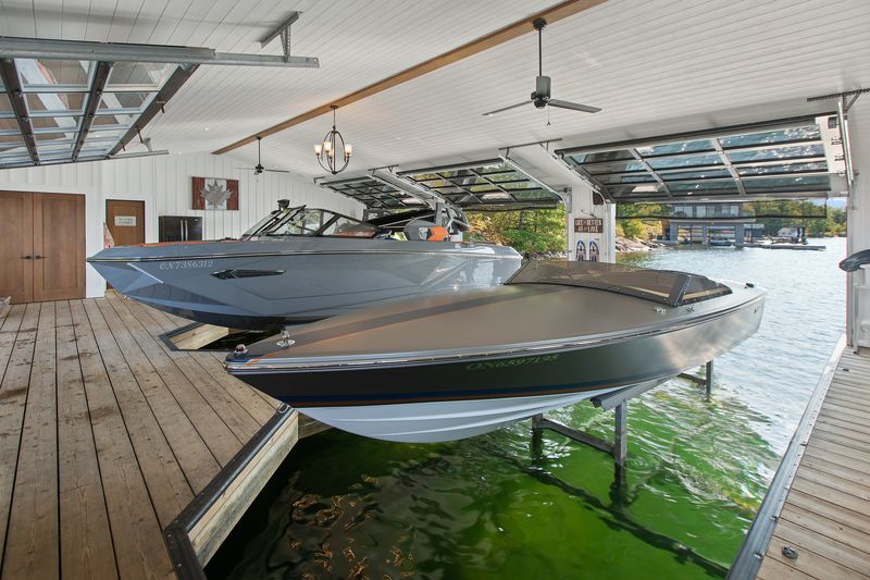 Two boats on lifts in modern boathouse
