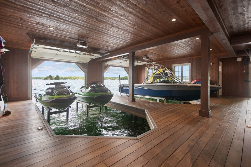 PWC and boat on lifts in boathouse interior