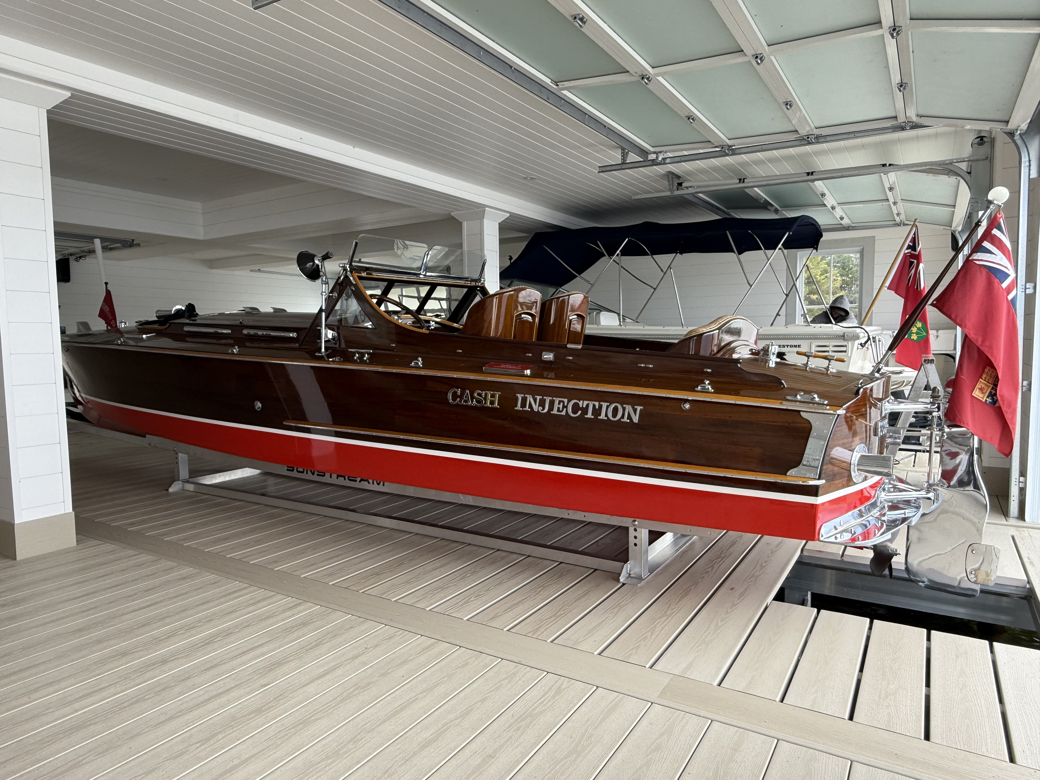 Classic wooden boat on Sunstream lift inside premium Ontario boathouse